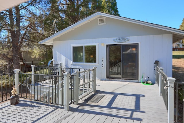 rear view of property featuring a wooden deck