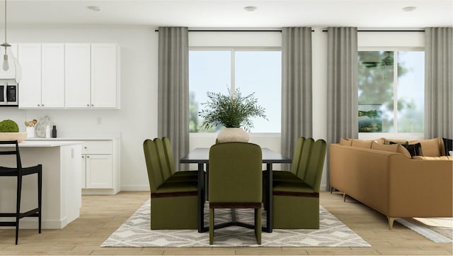 dining area with plenty of natural light, light wood-style flooring, and baseboards