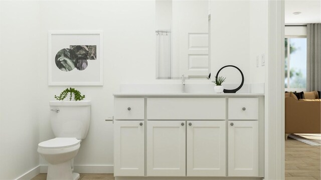 bathroom featuring vanity, toilet, and hardwood / wood-style floors