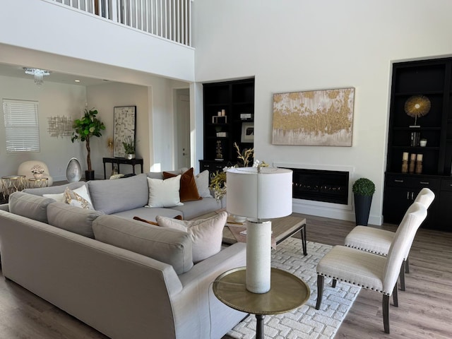 living room featuring hardwood / wood-style flooring and a towering ceiling