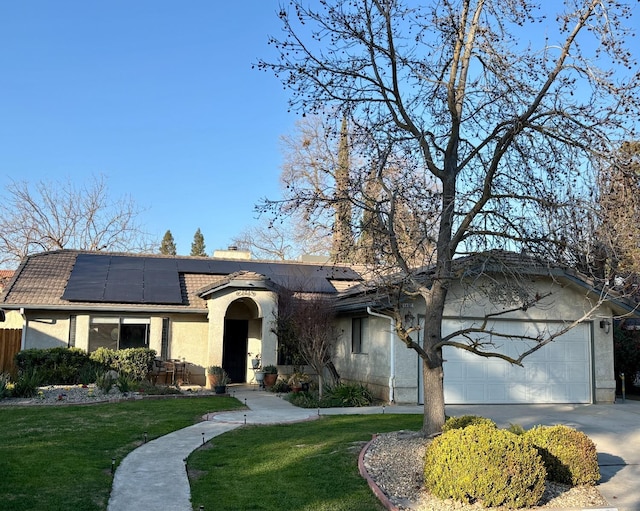 single story home with a garage, a front yard, and stucco siding