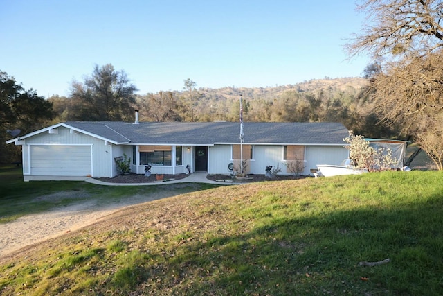 single story home featuring a garage, a front lawn, and a porch