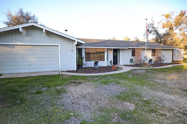 ranch-style house with a garage and a front lawn