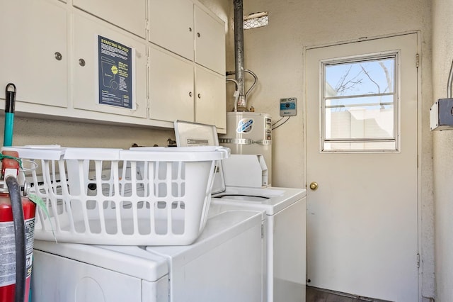 laundry room featuring cabinets, washer and clothes dryer, and secured water heater