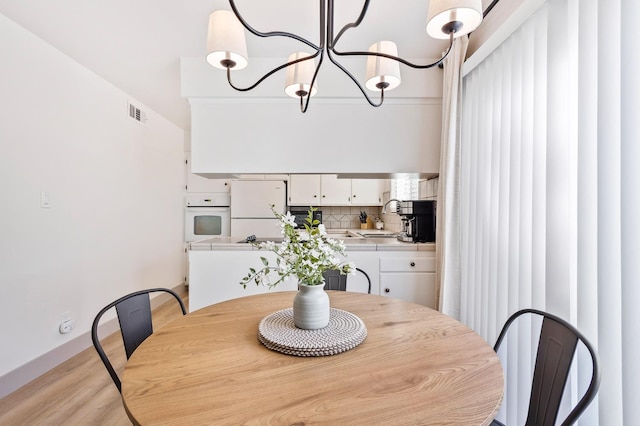 dining room featuring light hardwood / wood-style floors, a chandelier, and sink