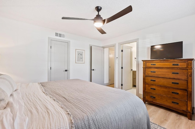 bedroom with light wood-type flooring, a textured ceiling, and ceiling fan