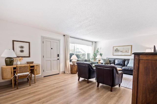 living room with light hardwood / wood-style flooring and a textured ceiling