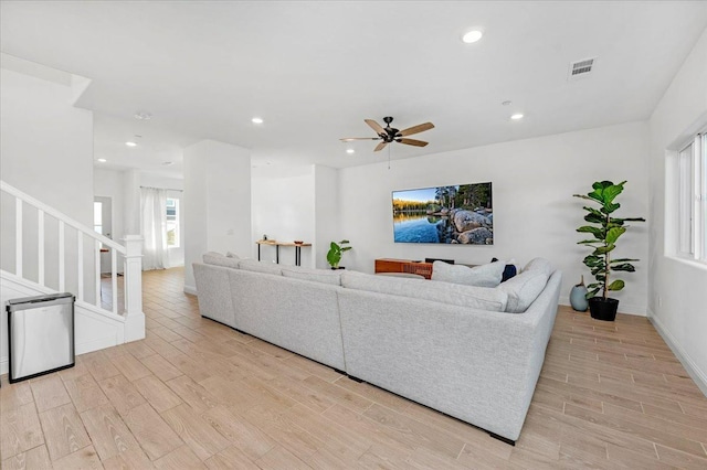 living room featuring ceiling fan and light wood-type flooring