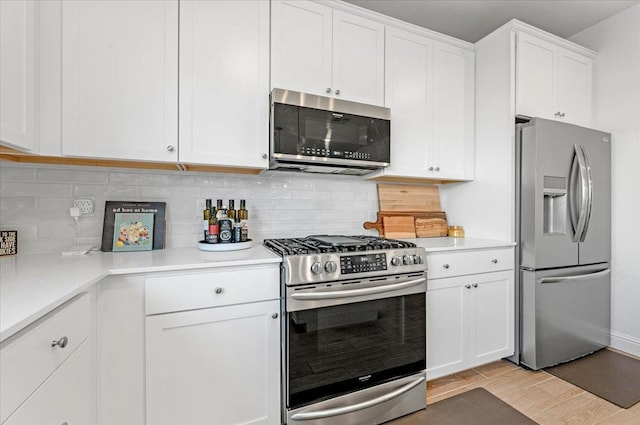 kitchen with white cabinetry, tasteful backsplash, stainless steel appliances, and light wood-type flooring