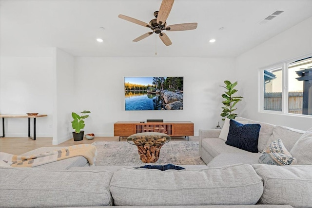 living room with light hardwood / wood-style flooring and ceiling fan