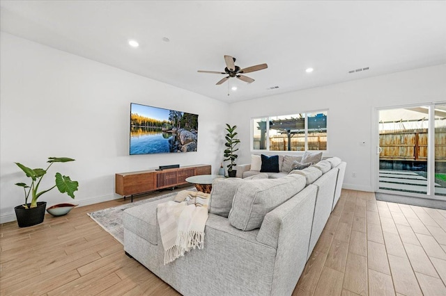 living room with ceiling fan, light hardwood / wood-style flooring, and a healthy amount of sunlight