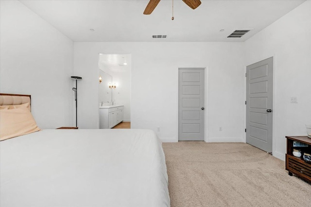 bedroom featuring connected bathroom, light colored carpet, and ceiling fan