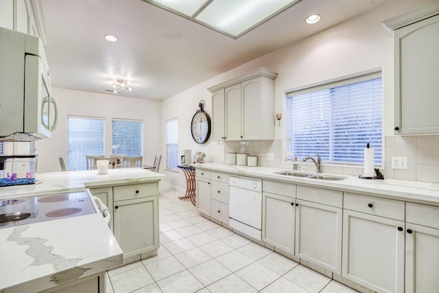 kitchen with light tile patterned flooring, sink, tasteful backsplash, kitchen peninsula, and white appliances