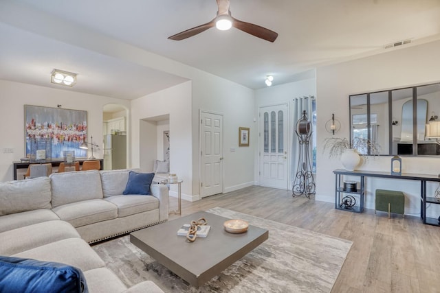 living room featuring ceiling fan and light hardwood / wood-style flooring