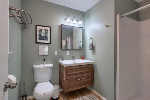 bathroom with vanity, wood-type flooring, walk in shower, and toilet