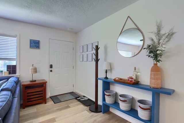 foyer with a textured ceiling and light wood-type flooring