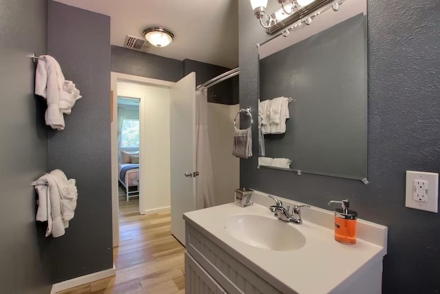 bathroom with a shower with curtain, vanity, and hardwood / wood-style floors