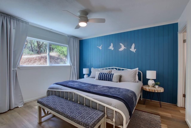 bedroom featuring wood-type flooring, ornamental molding, and ceiling fan