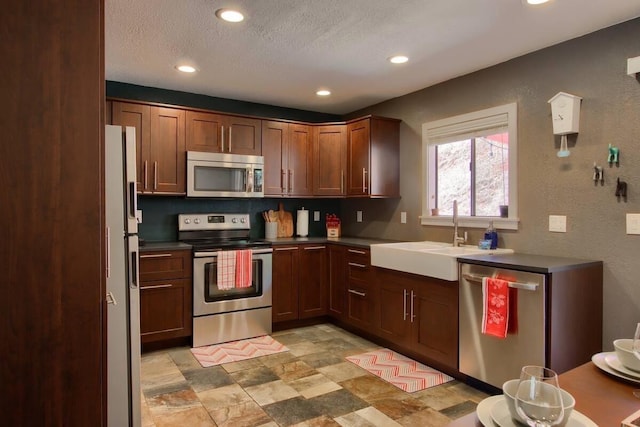 kitchen with stainless steel appliances, sink, and a textured ceiling