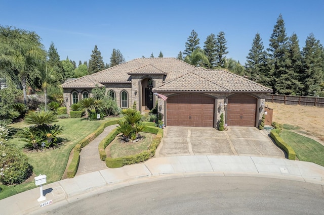 mediterranean / spanish-style house featuring a garage and a front yard