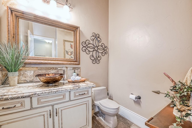 bathroom featuring vanity, tile patterned flooring, and toilet