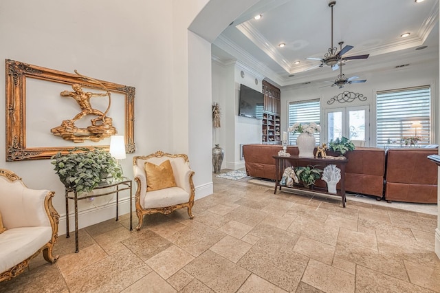 sitting room featuring a tray ceiling, ornamental molding, and ceiling fan