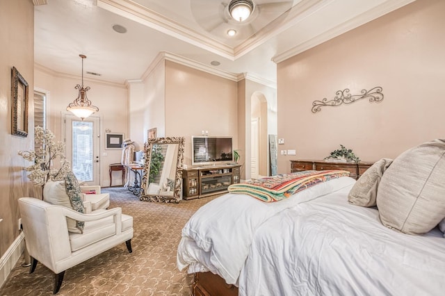 bedroom with ceiling fan, ornamental molding, a tray ceiling, and carpet