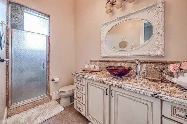 bathroom with vanity, toilet, a shower with shower door, and tile patterned flooring