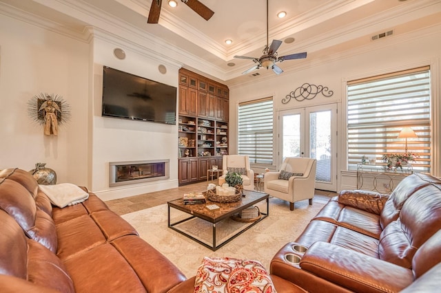 living room featuring crown molding, built in features, and ceiling fan