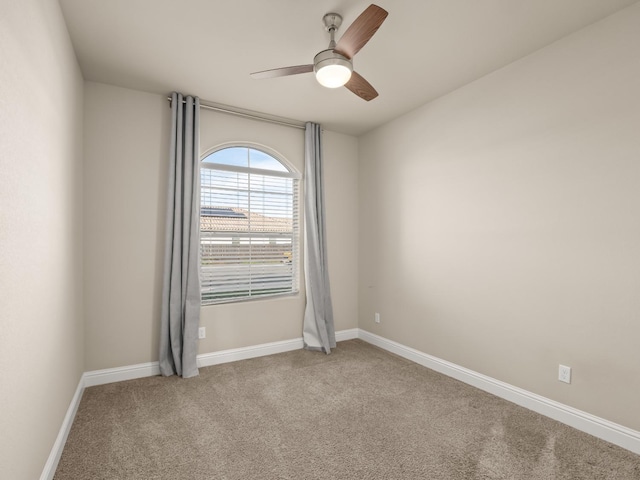 carpeted spare room featuring ceiling fan