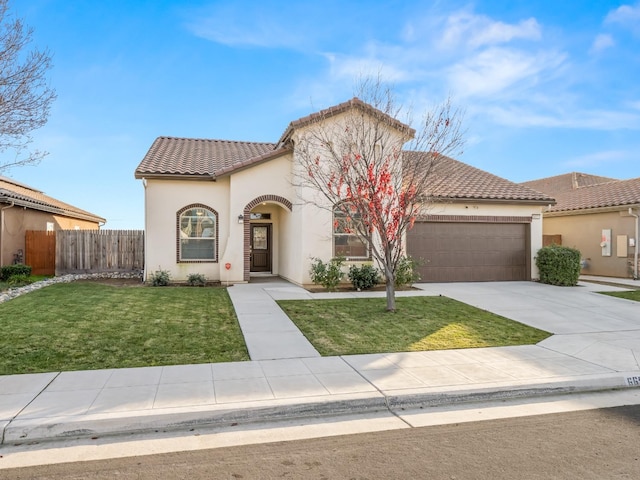 mediterranean / spanish home featuring a garage and a front lawn