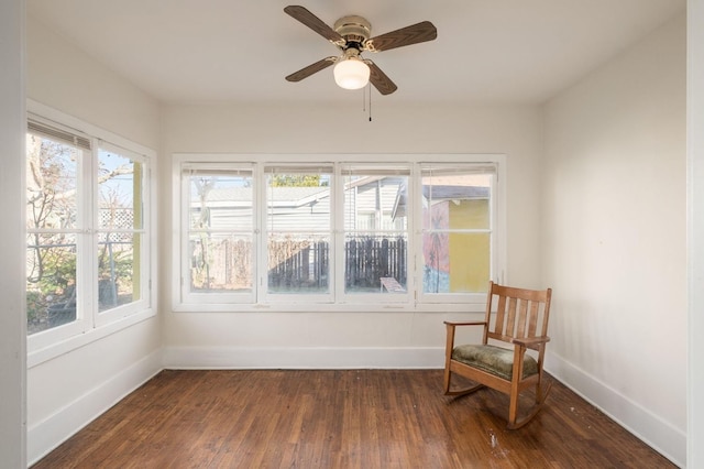 living area featuring dark wood-type flooring and ceiling fan