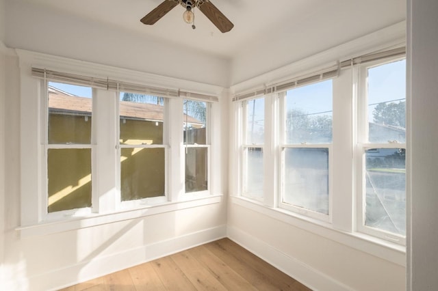 unfurnished sunroom featuring ceiling fan