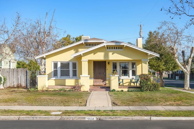 bungalow featuring central AC, covered porch, and a front lawn