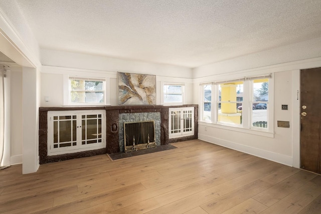 unfurnished living room featuring wood-type flooring and a textured ceiling