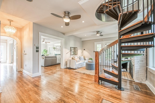 interior space with ceiling fan with notable chandelier and light hardwood / wood-style floors