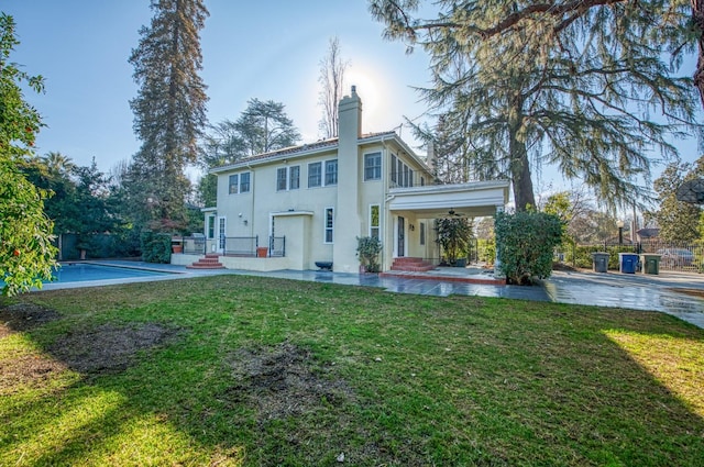 back of property featuring a yard, a balcony, and ceiling fan