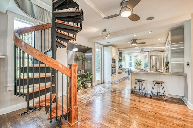 interior space featuring a wealth of natural light, ceiling fan, and light hardwood / wood-style flooring