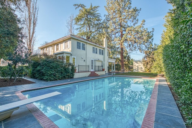 view of swimming pool featuring a diving board