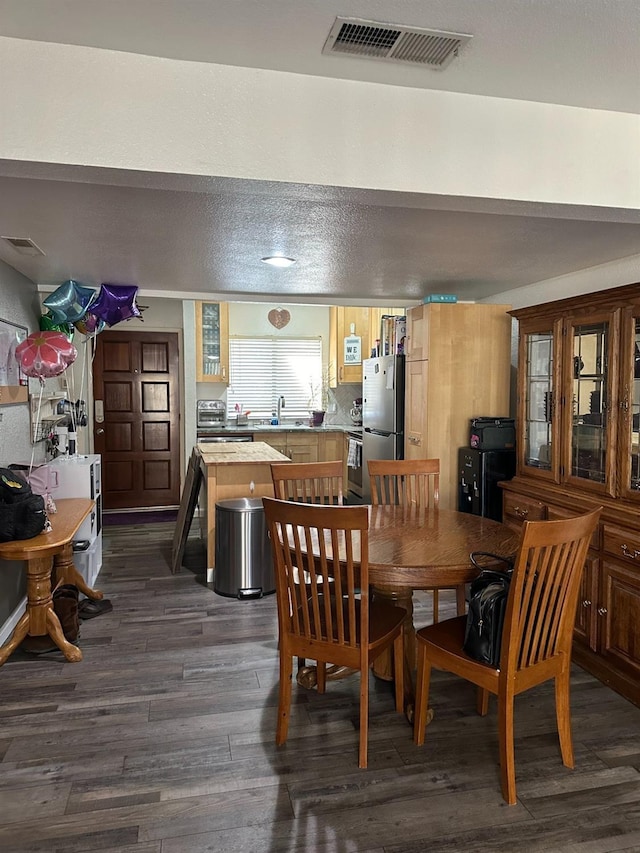 dining room with dark hardwood / wood-style flooring and sink