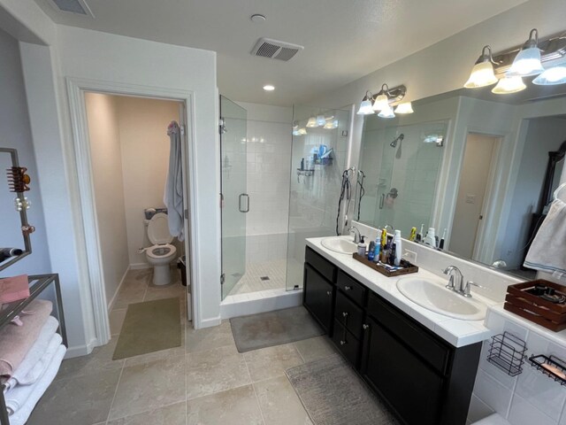 bathroom with walk in shower, vanity, toilet, and tile patterned flooring