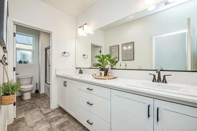 full bathroom with vanity, shower / bath combination with glass door, and toilet