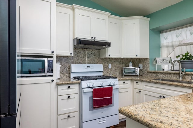 kitchen with tasteful backsplash, white cabinetry, sink, light stone countertops, and white gas stove