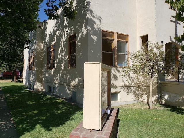 exterior space with a lawn and stucco siding