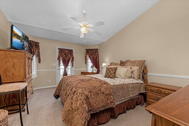 bedroom with vaulted ceiling, light colored carpet, and ceiling fan