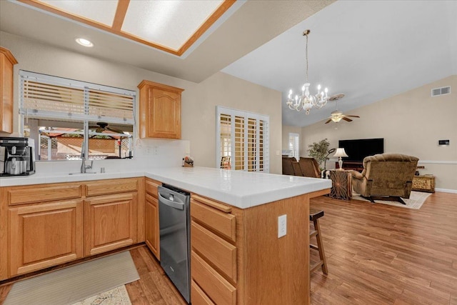 kitchen with hanging light fixtures, lofted ceiling, stainless steel dishwasher, and kitchen peninsula