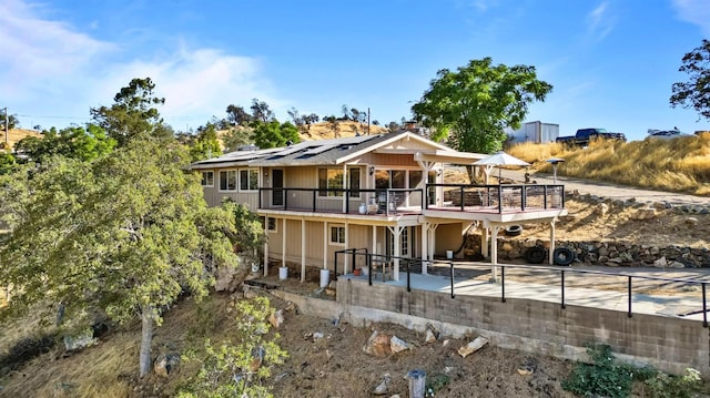 back of property featuring a patio and solar panels