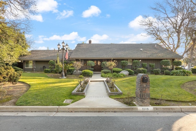 single story home featuring a front lawn