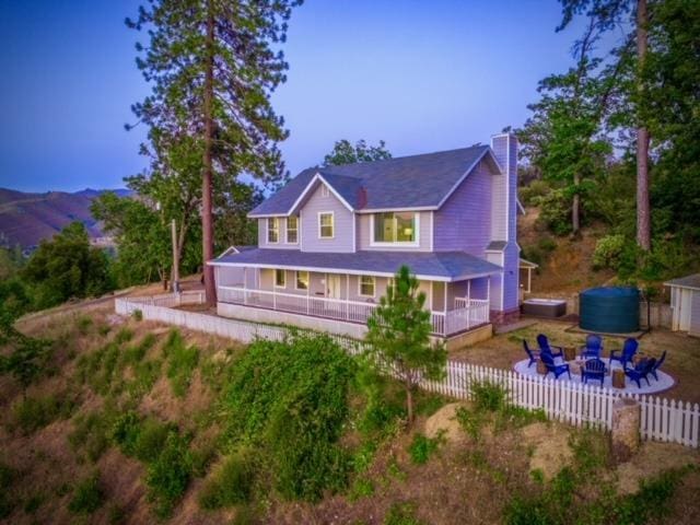 rear view of property with a sunroom, a mountain view, and a fire pit