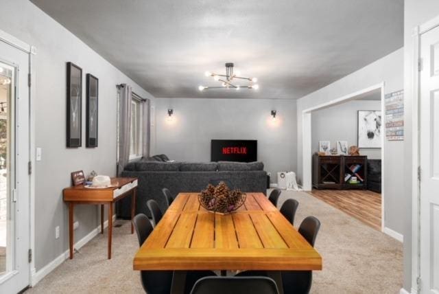 carpeted dining space with an inviting chandelier